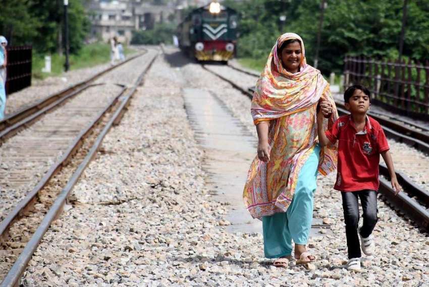 راولپنڈی: خاتون کسی خطرے کی پرواہ کئے بغیر ریلوے ٹریک کے ..