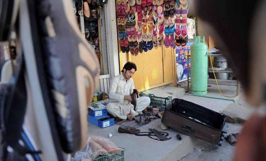 اسلام آباد: موچی اپنے سٹال پر بیٹھا جوتوں کی مرمت میں مصروف ..