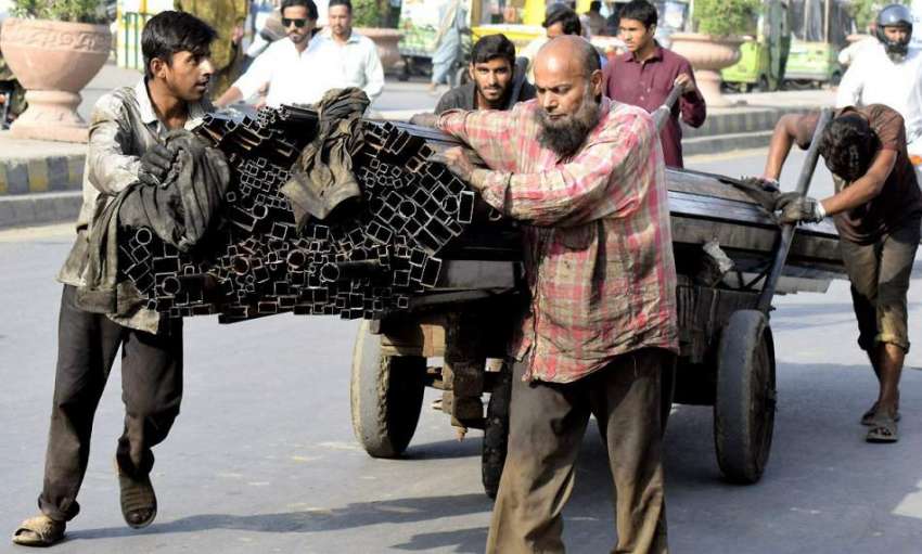 لاہور: مزدور ہتھ ریڑھی پر لوہے کا وزنی سامان رکھ کر لیجا ..