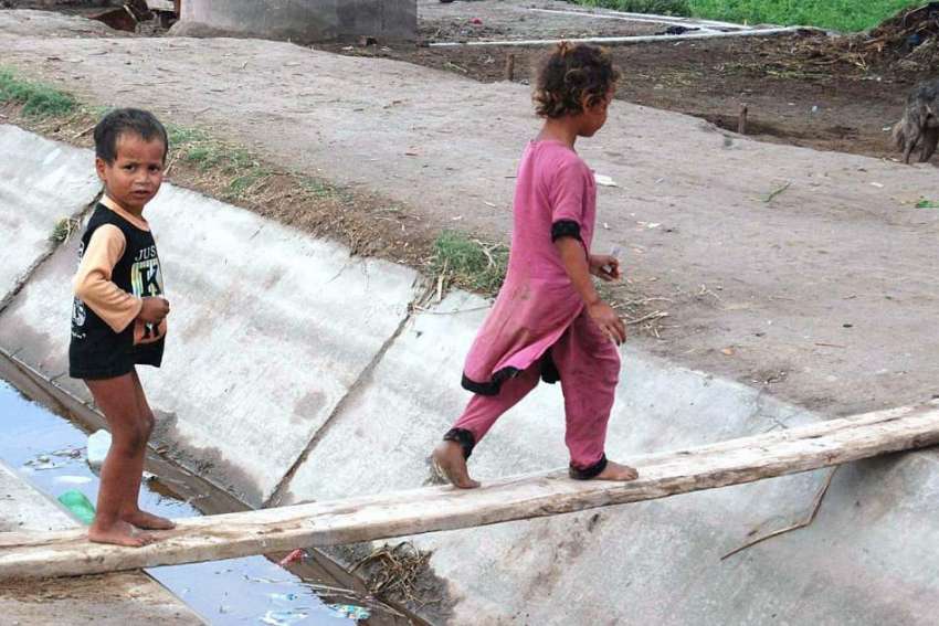 فیصل آباد: بچے عارضی پل کے ذریعے نہر کراس کر رہے ہیں۔