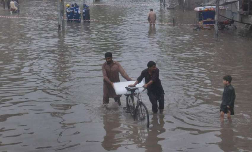 لاہور: موسلا دھار بارش کے بعد شہری سائیکل پر برف رکھے سڑک ..