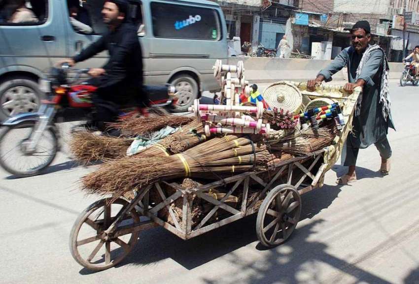 پشاور: محنت کش ہتھ ریڑھی پر گھریلو استعمال کی اشیاء رکھے ..