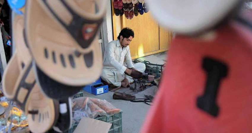 اسلام آباد: موچی اپنے سٹال پر بیٹھا جوتوں کی مرمت میں مصروف ..