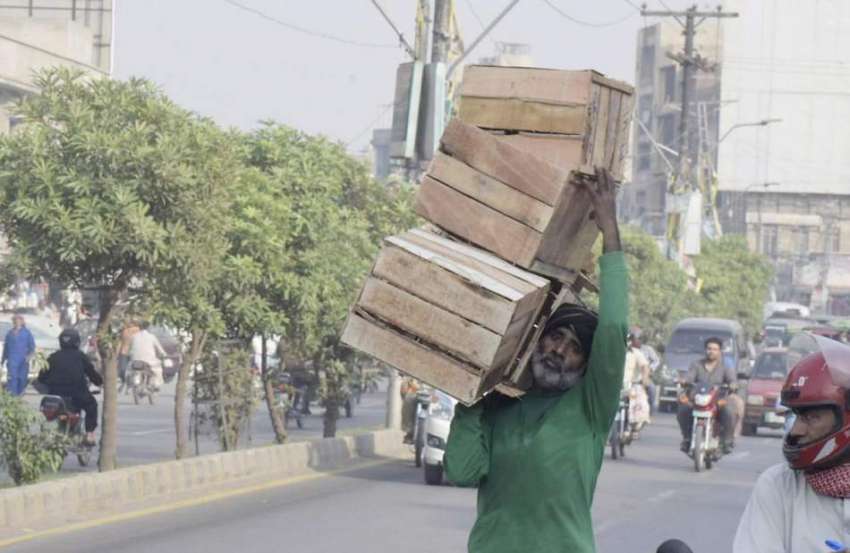لاہور: ایک شخص لکڑی کے خالی کریٹ لیکر جا رہا ہے۔