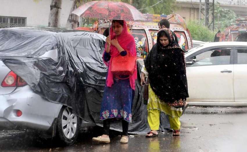 راولپنڈی: شہر میں ہونے والی بارش کے دوران خواتین بارش سے ..