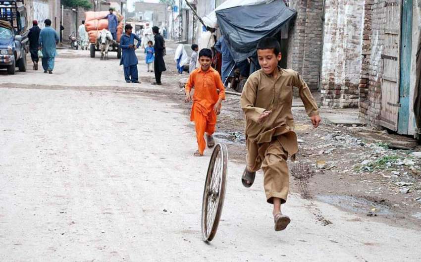 پشاور: بچے سائیکل کے ویل سے کھیل رہے ہیں۔
