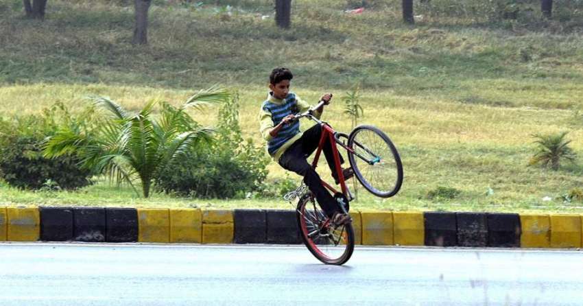 راولپنڈی: ایک نوجوان سائیکل پر ون ویلینگ کر رہا ہے جو کسی ..