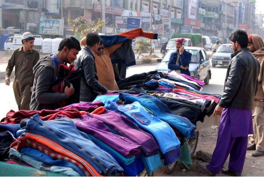 اسلام آباد: شہری سڑک کنارے لگے سٹال سے گرم کپڑے پسند کررہے ..