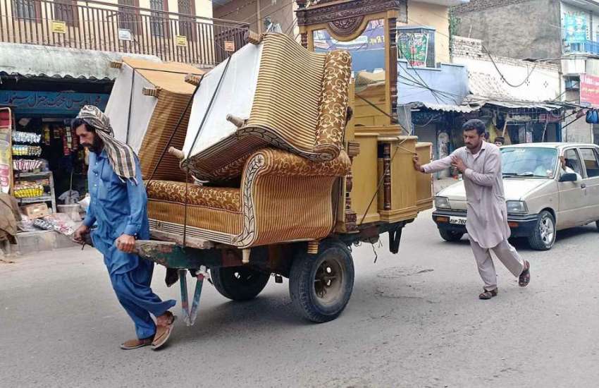 راولپنڈی: محنت کش ہتھ ریڑھی پر صوفے رکھے لیجا رہا ہے۔