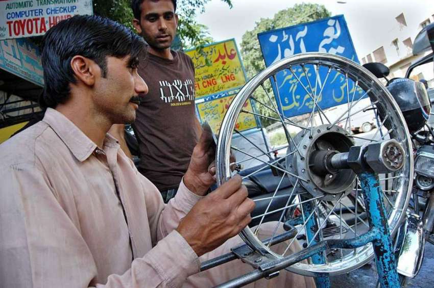 اسلام آباد: مکینک اپنی ورکشاپ میں وہیل بیلنس کرنے میں مصروف ..
