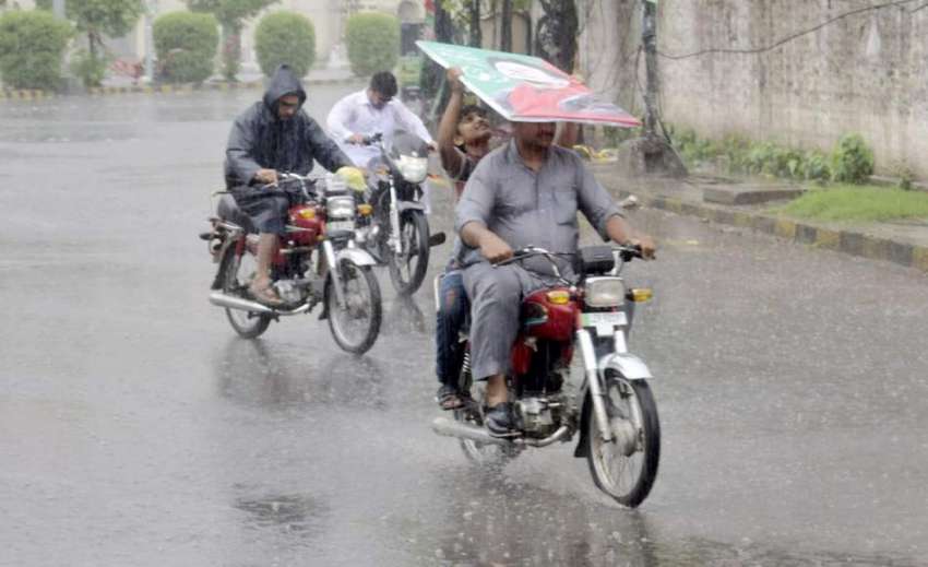 لاہور: شہر میں ہونیوالی بارش سے بچنے کے لیے موٹر سائیکل سواروں ..