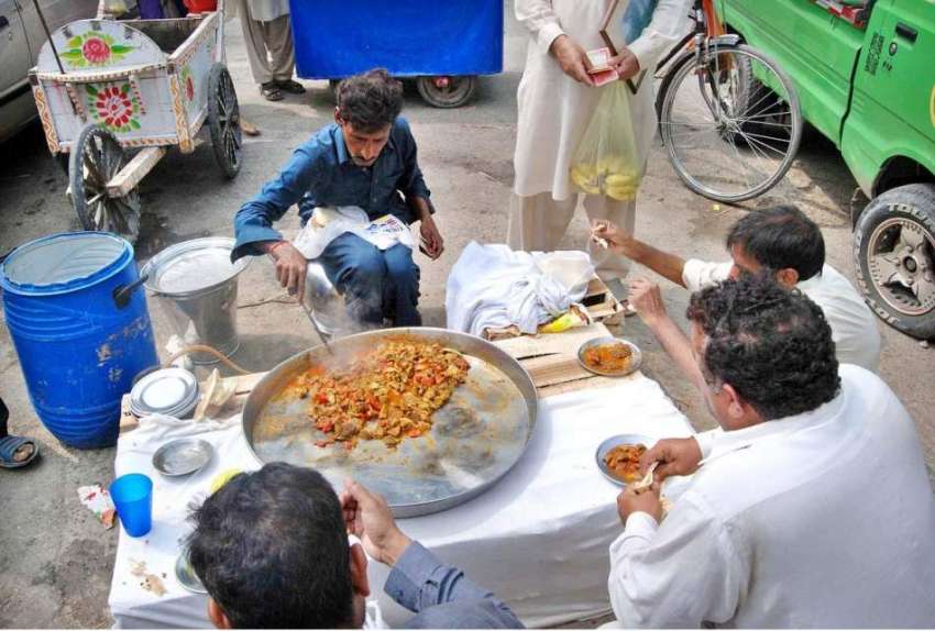اسلام آباد: شہری سڑک کنارے لگے سٹال سے کھانا کھا رہے ہیں۔