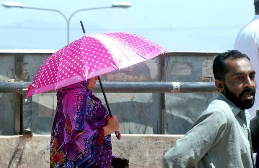 اسلام آباد: خاتون گرمی اور دھوپ کی شدت سے بچنے کے لیے چھتری ..
