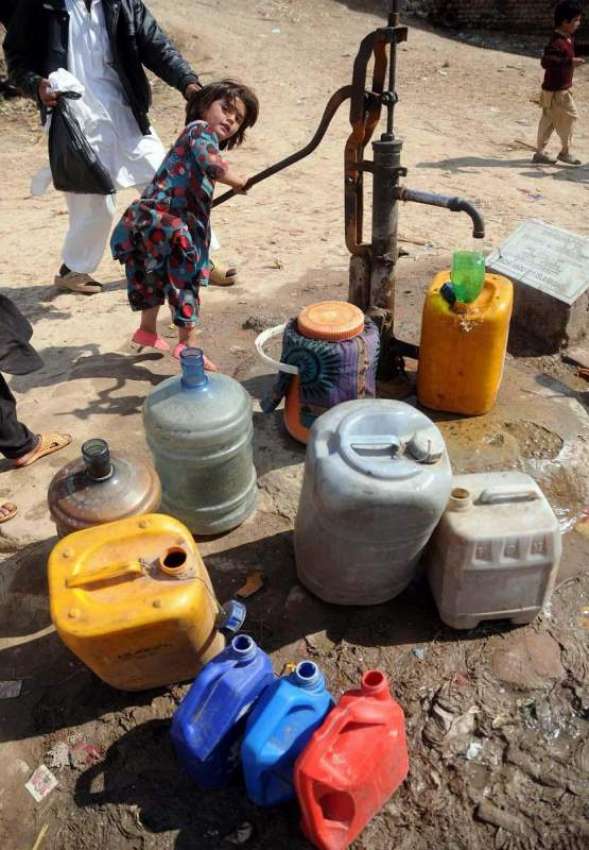 راولپنڈی: ایک کمسن بچی ہینڈ پمپ سے پینے کا پانی بھر رہی ہے۔