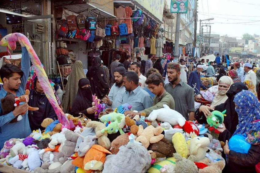 ملتان: شہری سڑک کنارے لگے سٹال سے کھلونے خرید رہے ہیں۔