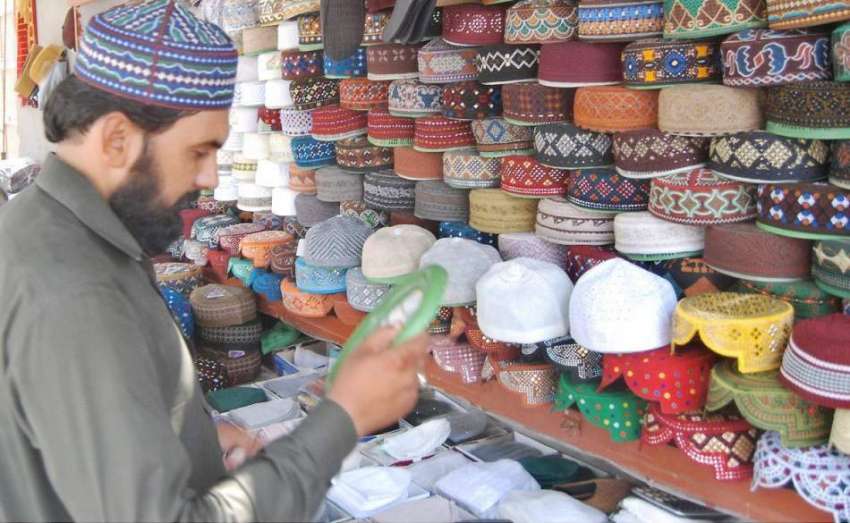 لاہور: شہری مال روڈ پر مسجد شہداء کے باہر ٹوپی خریدنے کے ..