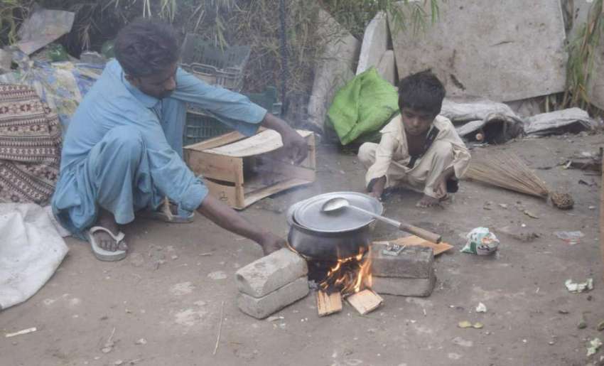 لاہور: خانہ بدوش شخص کھلے آسمان تلے کھانا تیار کر رہا ہے۔