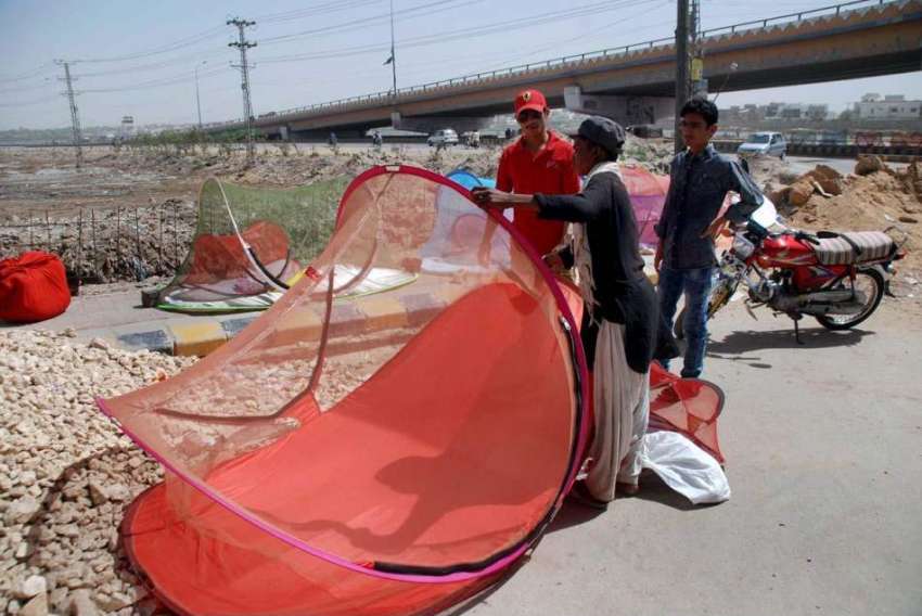 حیدر آباد: ایک محنت کش سڑک کنارے مچھردانیاں فروخت کر رہا ..