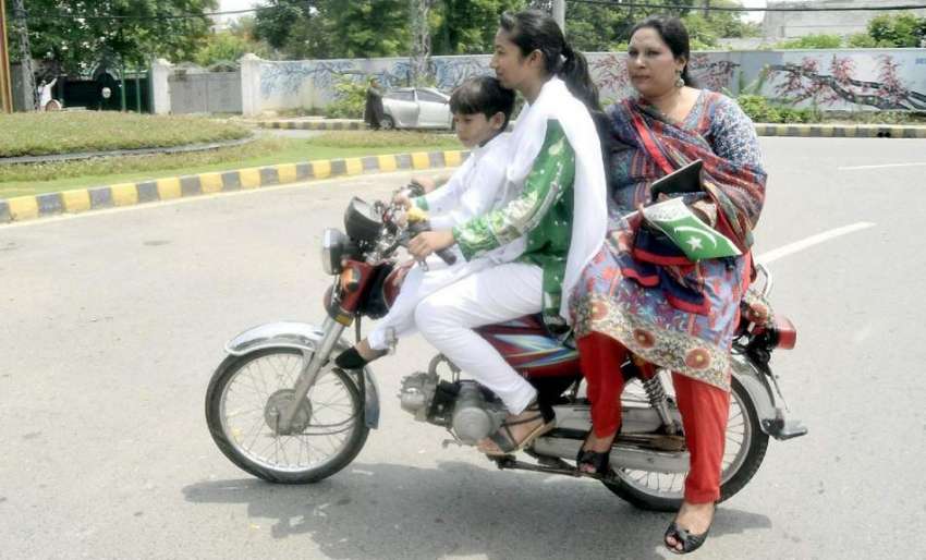 لاہور: یوم آزادی پر ایک لڑکی موٹر سائیکل پر اپنی والدہ کو ..