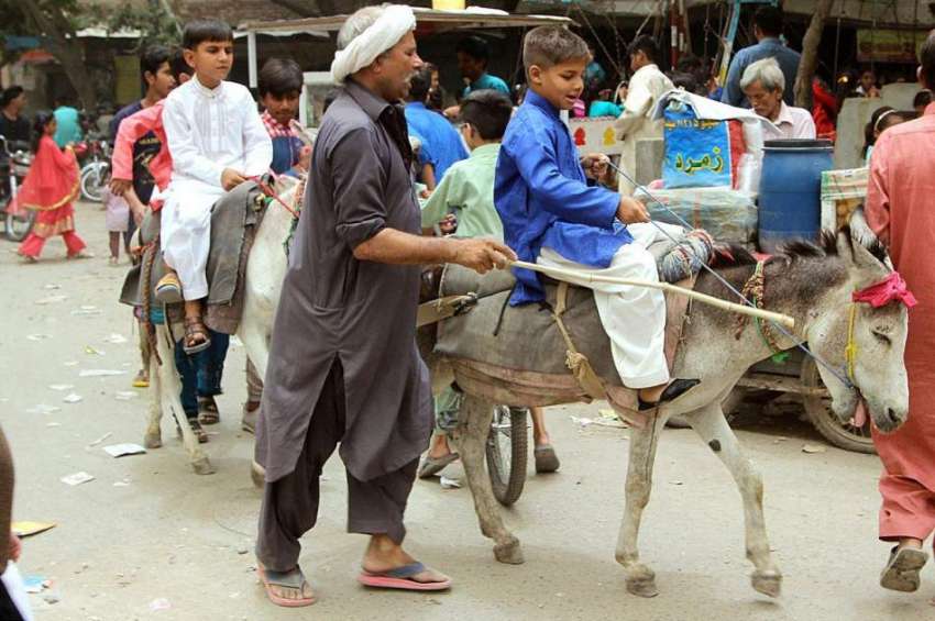 لاہور: ایک کمسن بچہ گدھے کی سواری سے لطف اندوز ہو رہا ہے۔