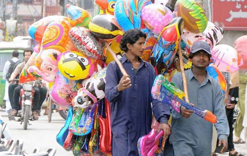 راولپنڈی: محنت کش غبارے اٹھائے فروخت کے لیے جارہا ہے۔