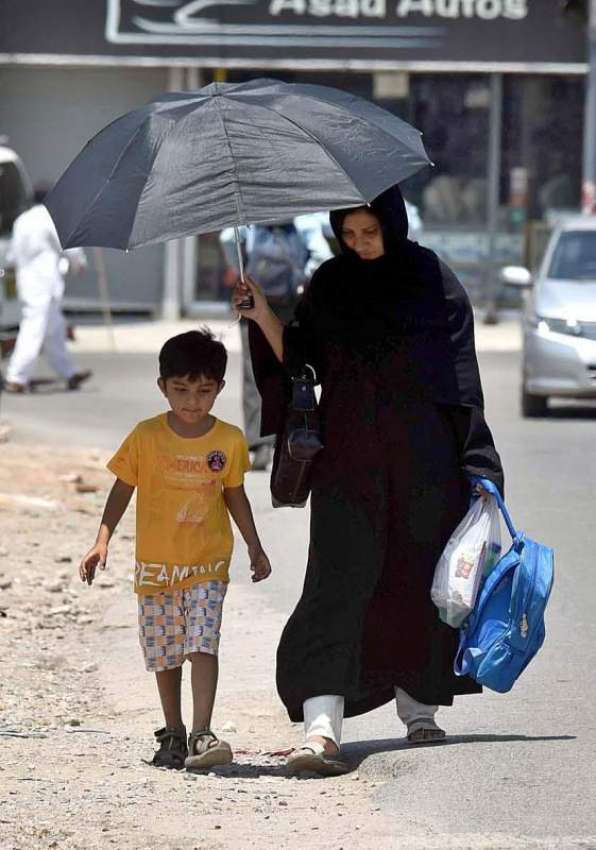 راولپنڈی: خاتون دھوپ کی شدت سے بچنے کے لیے چھتری تانے جا ..