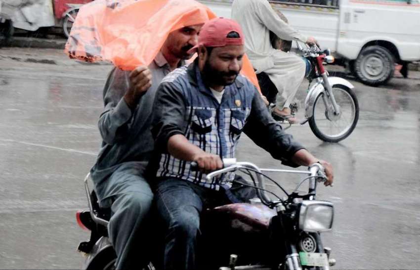 را ولپنڈی: موٹر سائیکل سوار بارش سے بچنے کے لیے پلاسٹک شیٹ ..