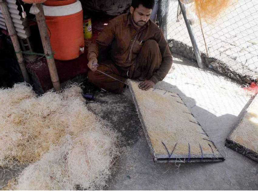 راولپنڈی: کاریگر ایک کارخانے میں رومکولر کی خسیں تیار کرنے ..