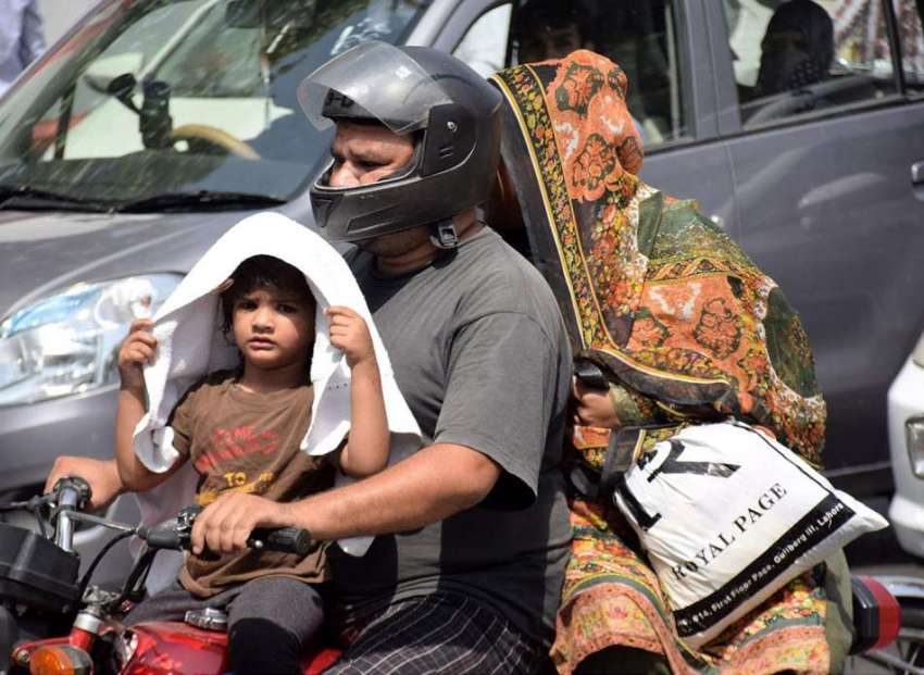 لاہور: اپنے والدین کے ہمراہ موٹر سائیکل پر جانے والی بچی ..