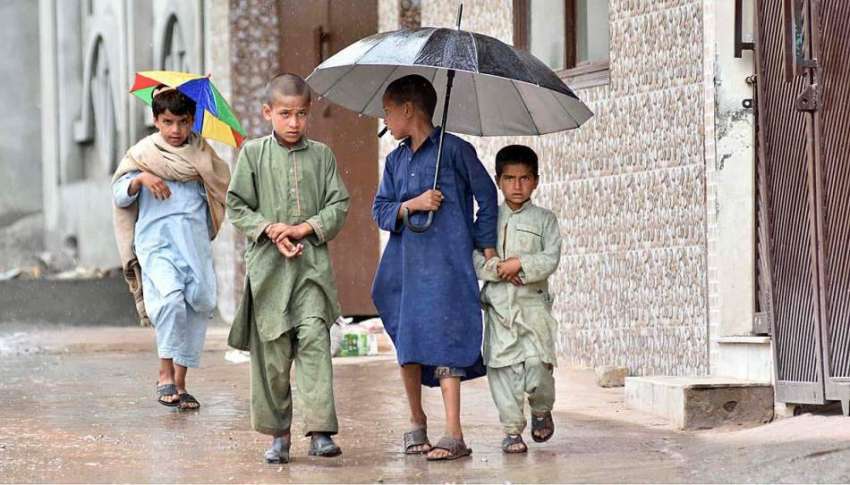 اسلام آباد: بچوں نے بارش سے بچنے کے لیے چھتری تان رکھی ہے۔
