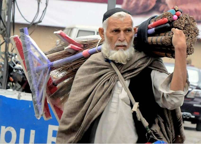راولپنڈی: معمر محنت کش سامان اٹھائے فروخت کے لیے جارہا ہے۔