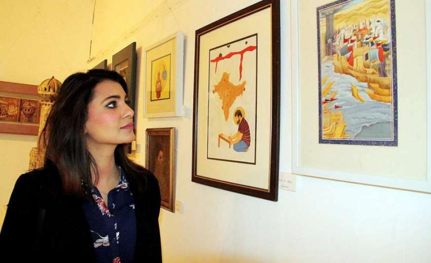 لاہور: الحمرا آرٹ گیلری میں ایک لڑکی پینٹنگز کی نمائش دیکھ ..