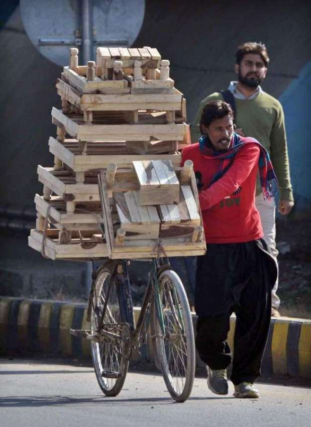 راولپنڈی: محنت کش پھیری لگا کر لکڑی کے سٹول فروخت کررہا ہے۔