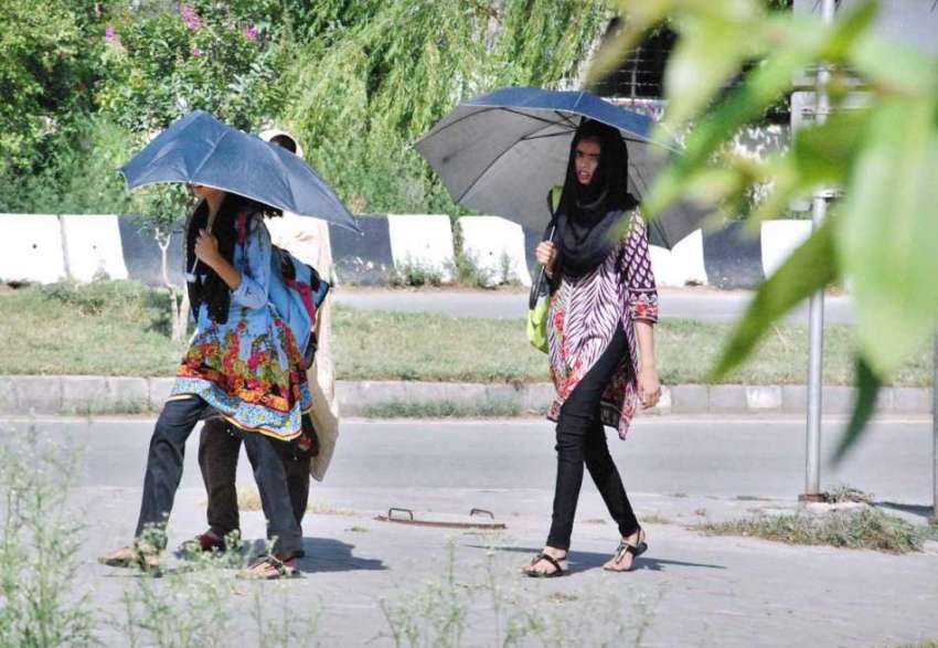 اسلام آباد: خواتین دھوپ کی شدت سے بچنے کے لیے چھتریاں تانے ..