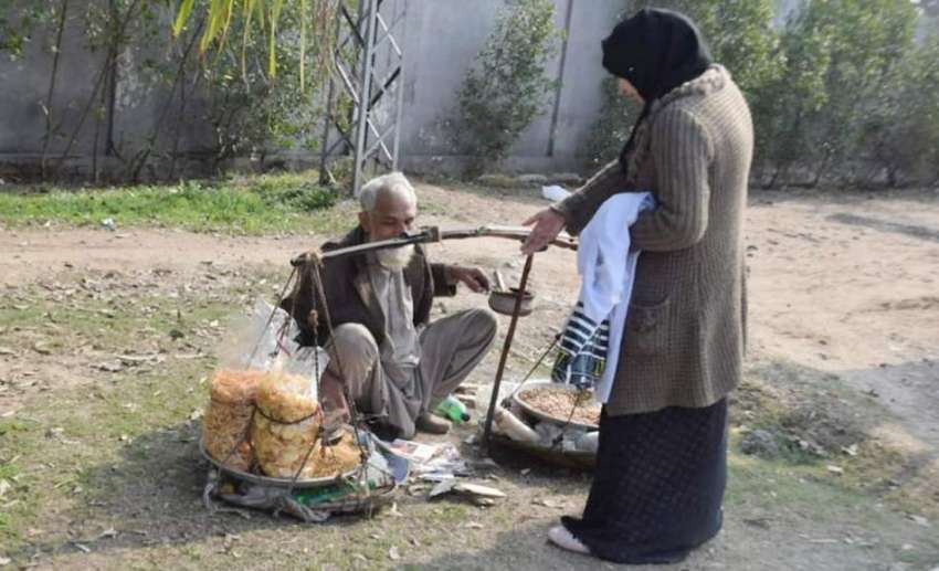لاہور: میڈیکل کی طالبہ ایک بزرگ سے کھانے کی اشیاء خرید رہی ..
