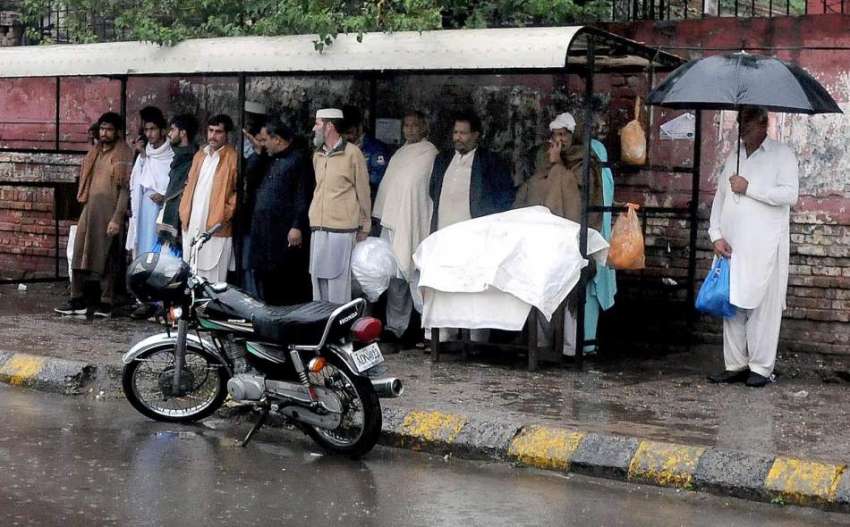 راولپنڈی: بارش سے بچنے کیلئے شہریوں سے ایک بس سٹاپ کے شیلٹر ..