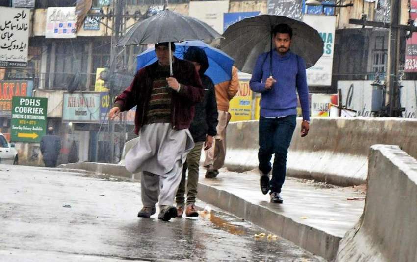 راولپنڈی: مری روڈ پر شہری بارش سے بچنے کے لیے چھتری تانے ..