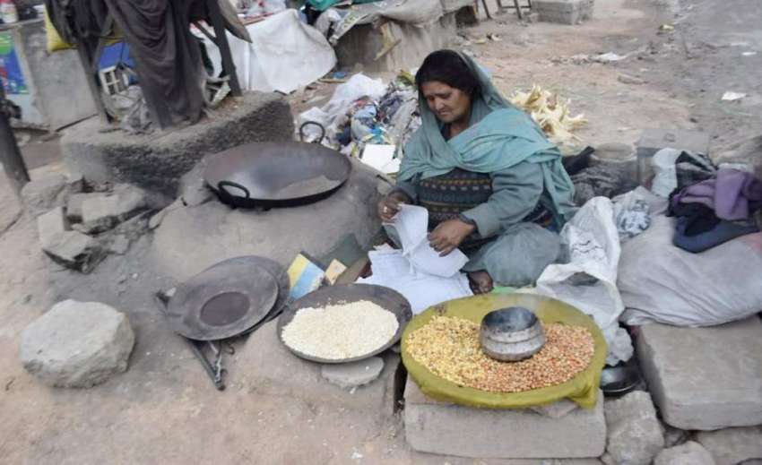 لاہور: ایک بھٹارن گاہکوں کے انتظار میں بیٹھی ہے۔