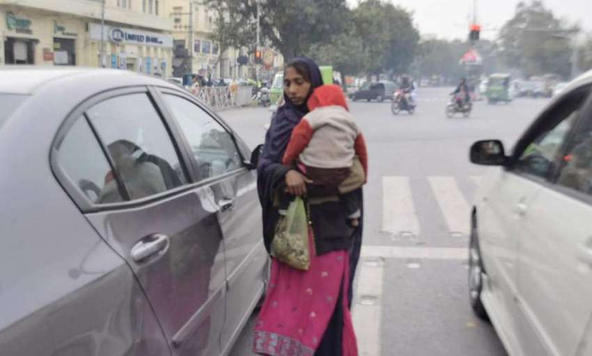 لاہور: ایک خاتون اپنے بچے کو اٹھائے ٹریفک سگنل پر بھیک مانگ ..