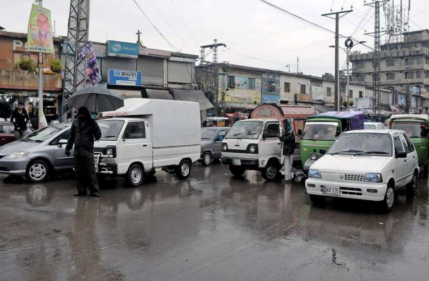 راولپنڈی: راجہ بازار میں ٹریفک پولیس اہلکار بارش کے دوران ..