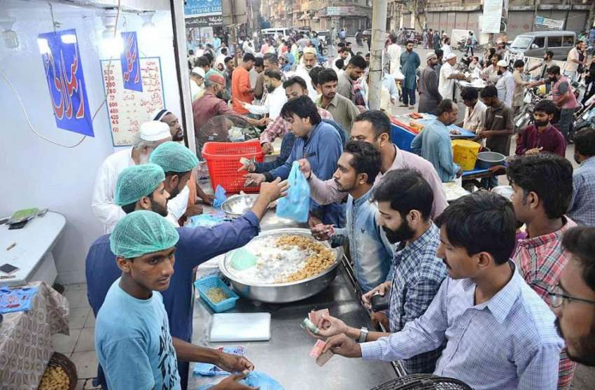 کراچی: شہری ایک دکان سے پکوڑے اور سموسے وغیرہ خرید رہے ہیں۔