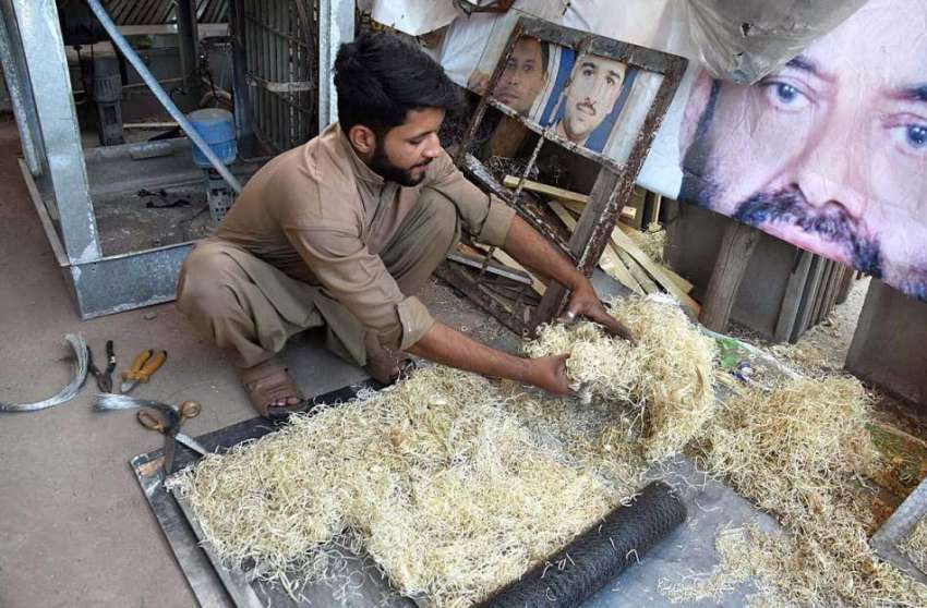 پشاور: محنت کش روم ائیر کولر کی خسیں بنانے میں مصروف ہے۔