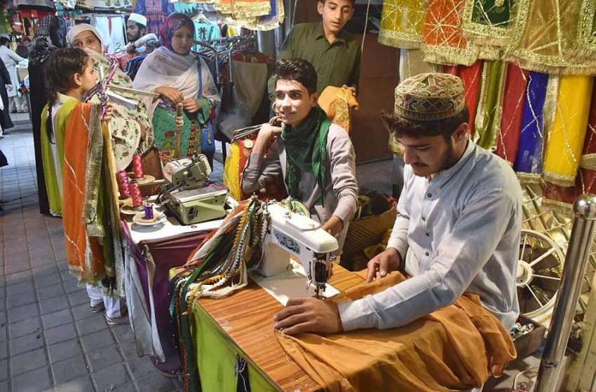 پشاور: عید کی تیاریوں میں مصروف درزی کپڑے سلائی کر رہے ہیں۔