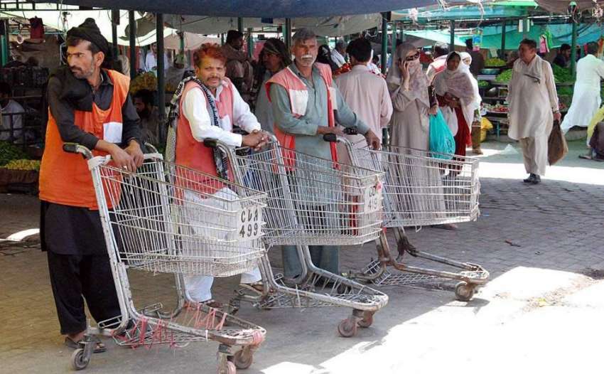اسلام آباد: مزدور ہفتہ وار بازار کے باہر ہتھ ریڑیاں لیے گاہکوں ..