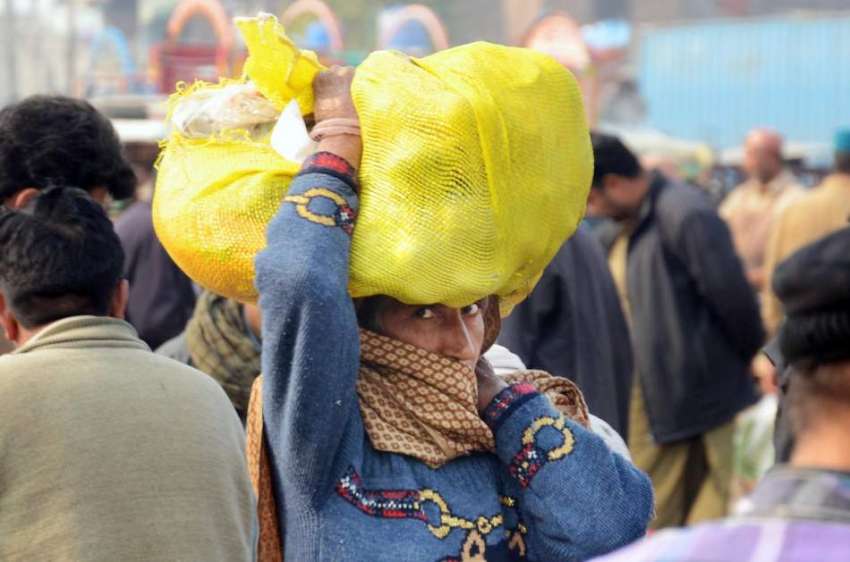 لاہور: خواتین کے عالمی دن کے موقع پر ایک خاتون سر پر سبزیوں ..