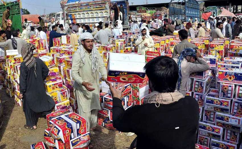 اسلام آباد: مزدور فروٹ منڈی میں فروٹ کی پیٹیاں فروخت کے لیے ..