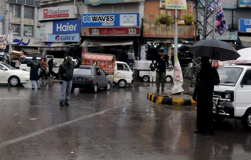 راولپنڈی: راجہ بازار میں ٹریفک پولیس اہلکار بارش کے دوران ..