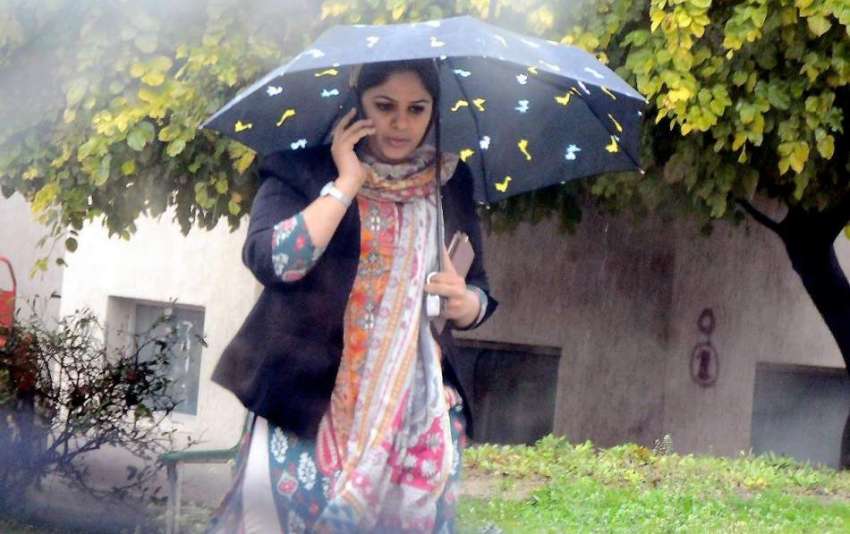 راولپنڈی: بارش سے بچنے کے لیے خاتون نے چھتری تان رکھی ہے۔