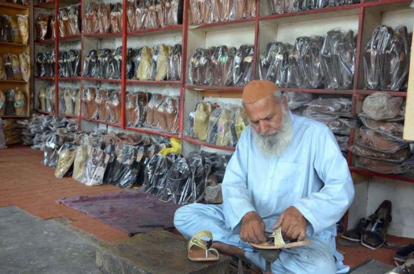 فیصل آباد: معمر محنت کش روایتی انداز سے جوتے بنانے میں مصروف ..