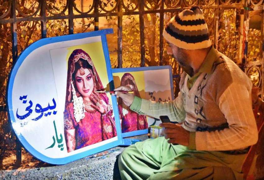 لاڑکانہ: ایک فنکار اپنے سڑک  کنارے پینٹنگز میں مصروف ہے۔